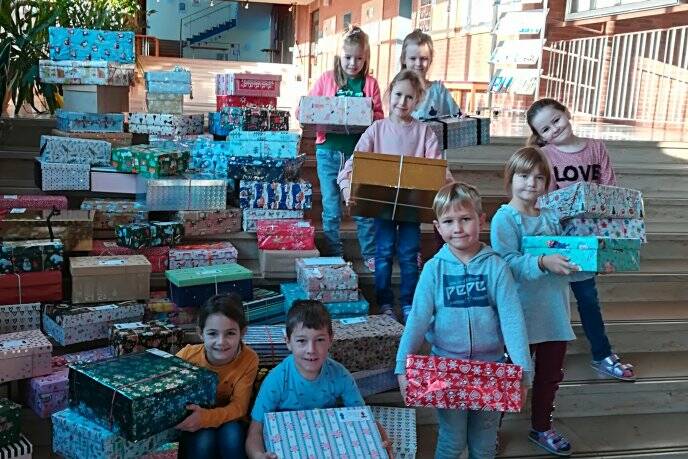 Geschenk mit Herz - Kinder präsentieren stolz die verpackten Geschenke